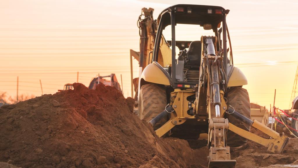 Construction vehicle on site with the sun behind it