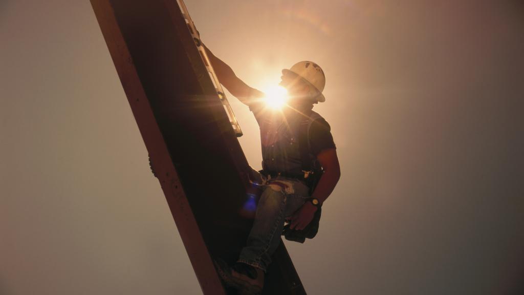 Construction work scaling an industrial structure