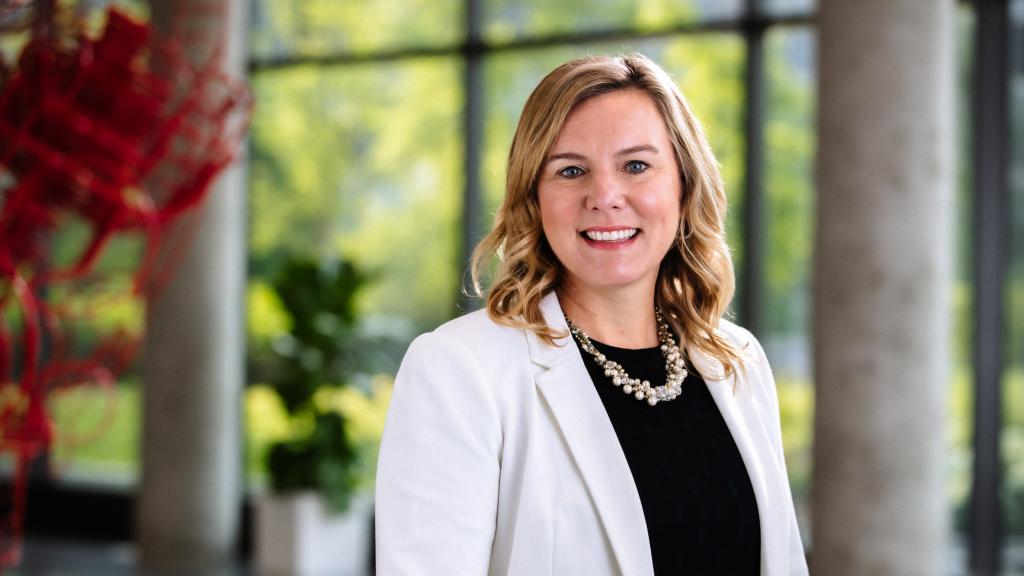 Amy Davis, President of Accelera, wearing a white blazer and black shirt; she is smiling at the camera