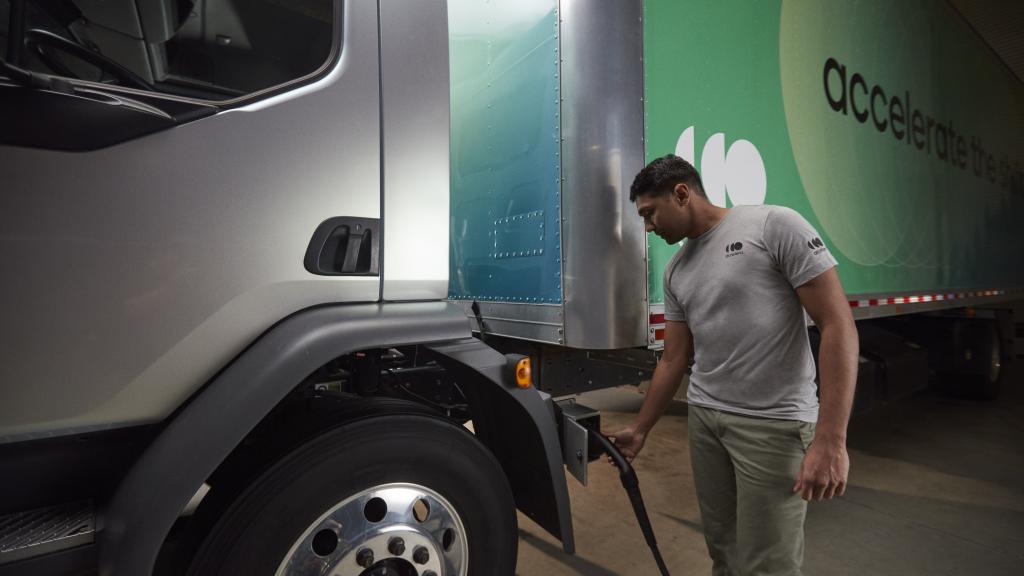 Accelera technician wearing a gray shirt and charging an electric, zero-emission truck