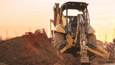 Construction vehicle on site with the sun behind it