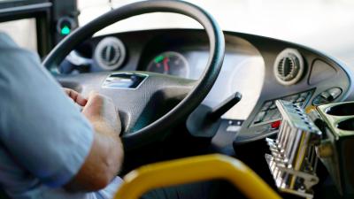 View of a public transit bus driver with hands on the wheel
