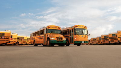 A parking lot filled with electric school buses