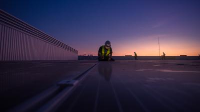 Techniker überprüfen morgens die Installation einer Solarzelle auf dem Dach der Fabrik
