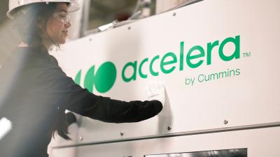 Accelera employee applying a green vinyl logo to an electrolyzer