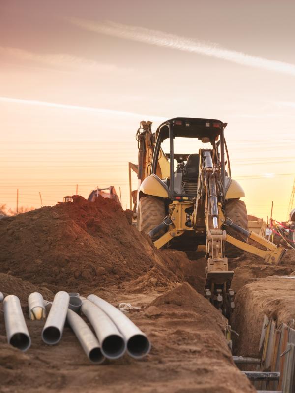 Construction vehicle on site with the sun behind it