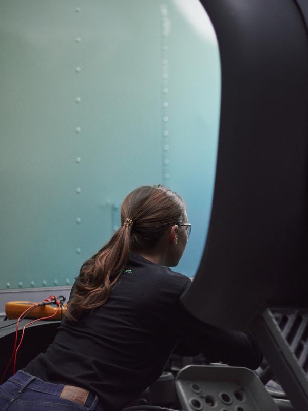 Female technician working under the hood of an Accelera zero-emission truck