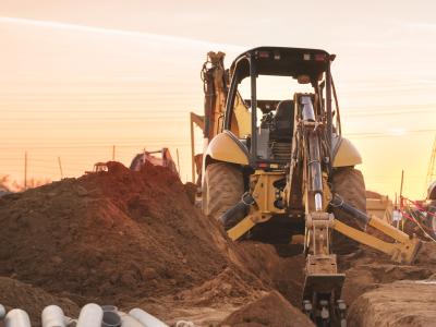 Construction vehicle on site with the sun behind it