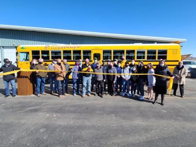 Mitglieder des West Grand School District durchschneiden ein gelbes Band vor einem Blue Bird-Schulbus mit Accelera-Antrieb