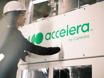 Accelera employee applying a green vinyl logo to an electrolyzer