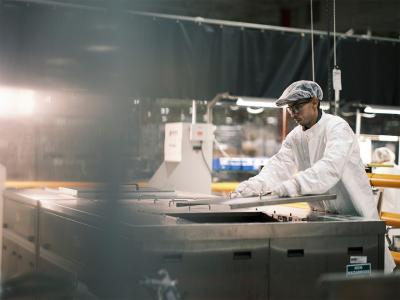 Man wearing personal protection equipment in a lab environment