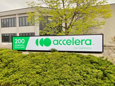 Sign with address and Accelera logo in front of a building