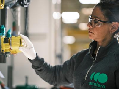 Woman wearing safety glasses and gloves touching a yellow valve
