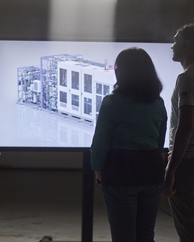 Three engineers looking at 3D rendering of PEM electrolyzer