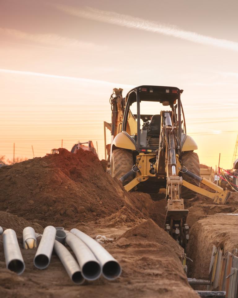 Vehículo de construcción en el sitio con el sol detrás