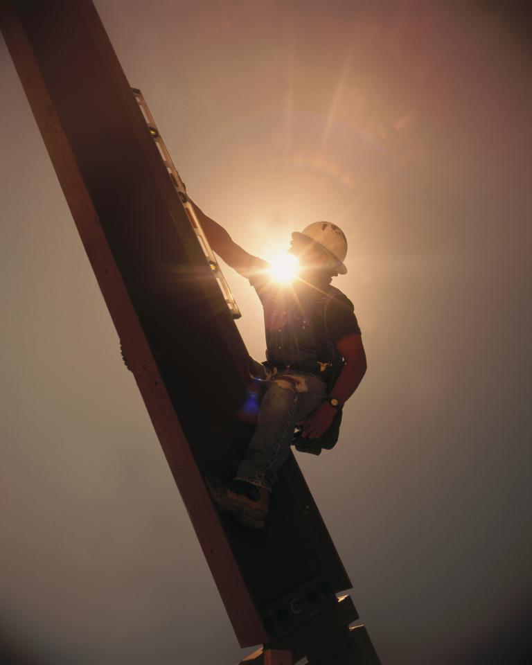 Construction work scaling an industrial structure