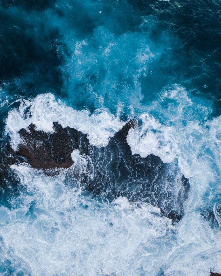 Ocean waves crashing around rocks