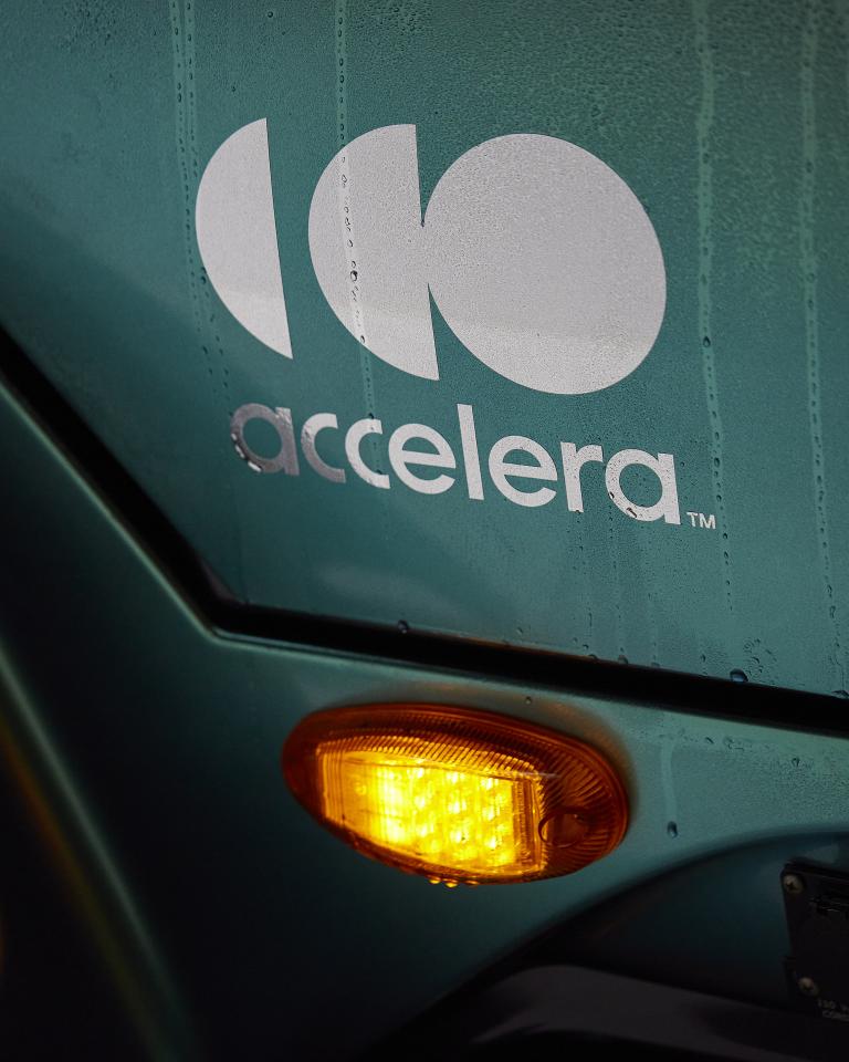Weißes Accelera-Logo auf der Tür eines emissionsfreien Fahrzeugs
