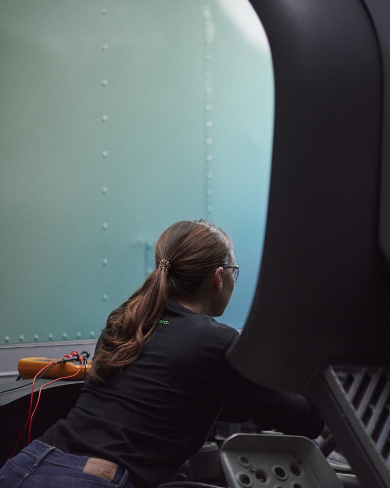 Female technician working under the hood of an Accelera zero-emission truck