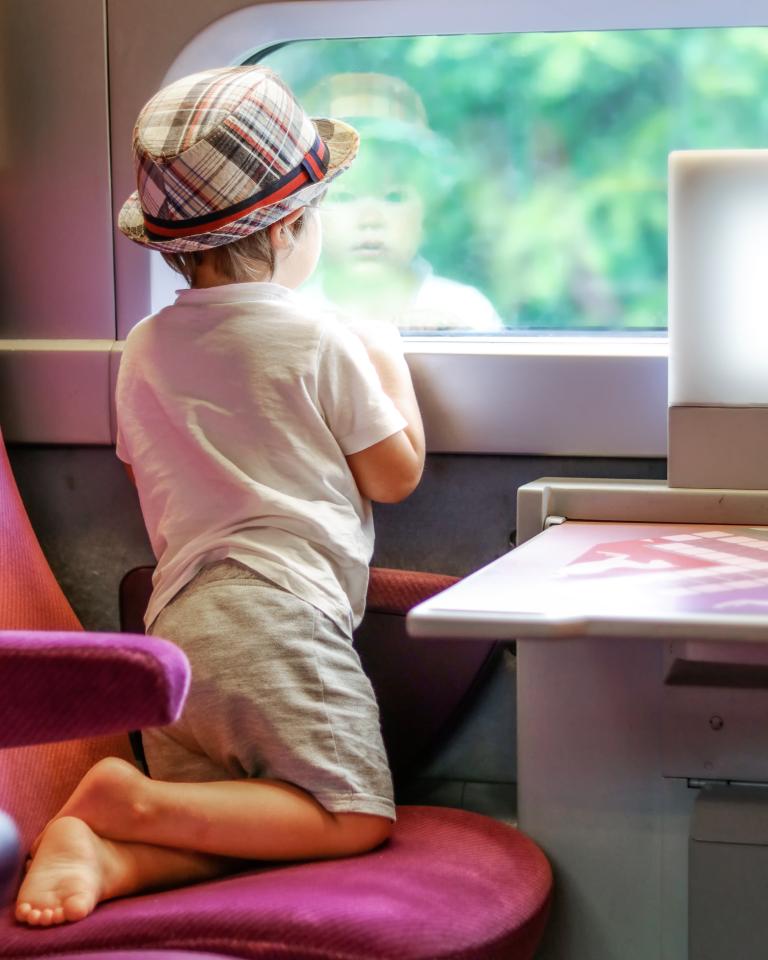 Niño mirando por la ventana del tren
